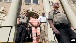 FILE - Francisco Oropeza, center, is escorted from the San Jacinto County courthouse by San Jacinto County Sheriff Greg Capers, second from right, May 18, 2023, in Coldspring, Texas.