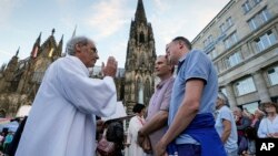 FILE - Same-sex couples take part in a public blessing ceremony in front of the Cologne Cathedral in Cologne, Germany, on Sept. 20, 2023. The Vatican said Dec. 18, 2023, in a ruling approved by Pope Francis that Catholic priests can administer blessings to same-sex couples.