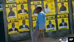 A boy leans near to campaign posters with images of candidates in Harare, Zimbabwe, on July 16, 2023.