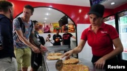 Yousy Oliva, de 34 años, sirve pizza en un restaurante de La Habana, el 16 de agosto de 2023.