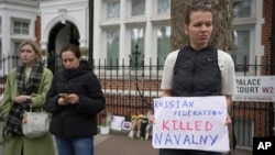 Protesters stand opposite the Russian Embassy in London, Feb. 16, 2024, in reaction to the news that jailed Russian opposition leader Alexey Navalny has died in a Russian prison.