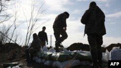 Ukrainian servicemen pile up bags of soil to build a fortification not far from the city of Avdiivka, in Ukraine's Donetsk region, amid Russia's invasion of Ukraine, Feb. 17, 2024.