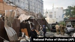 A police officer and a rescue worker walk in front of a restaurant destroyed by a Russian attack in Kramatorsk, Ukraine, June 27, 2023. (National Police of Ukraine via AP)