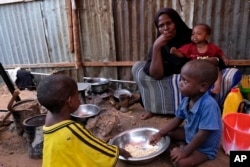 Hadiiq Abdulle Mohamed makan bersama anak-anaknya saat wawancara dengan Associated Press di kamp pengungsi internal di pinggiran Mogadishu, Somalia, Jumat, 24 Maret 2023. (AP/Farah Abdi Warsameh)