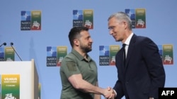 NATO Secretary-General Jens Stoltenberg shakes hands with Ukrainian President Volodymyr Zelensky after a joint press conference on the sidelines of the NATO Summit in Vilnius, July 12, 2023.