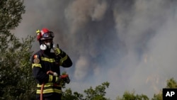 A firefighter from Romania tries to stop the fire at the village of Agia Sotira, Greece, near Athens, July 18, 2023.