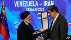 Iranian President Ebrahim Raisi shakes hands with Venezuelan President Nicolas Maduro, at Miraflores presidential palace in Caracas, Venezuela, June 12, 2023. 