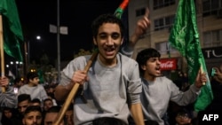 Palestinians prisoners (wearing grey) cheer among supporters after being released from Israeli jails in exchange for hostages released by Hamas from the Gaza Strip, in Ramallah in the occupied West Bank, early on Nov. 26, 2023. 
