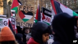 Protester hold flags and placards as they take part in a pro-Palestinian demonstration as they wend their way along Whitehall in London, Nov. 25, 2023.