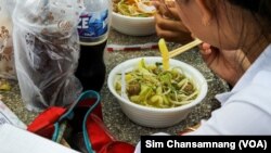 សិស្សម្នាក់​កំពុង​ហូប​អាហារ​របស់​គេ​ នៅ​វិទ្យាល័យ ជាស៊ីមចំរើនរដ្ឋ ក្នុង​រាជធានី​ភ្នំពេញ កាលពី​ថ្ងៃទី២២ ខែមីនា ឆ្នាំ២០២៣។ (ស៊ឹម ចាន់សំណាង/វីអូអេ)