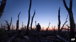 FILE - Ukrainian servicemen walk through a charred forest at the frontline a few kilometers from Andriivka, Donetsk region, Ukraine, Sept. 16, 2023.