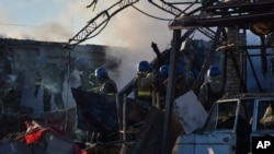 Members of the Ukrainian State Emergency Service clear the rubble at the building which was destroyed as a result of Russian strike in Zaporizhzhia district, Ukraine, March 31, 2023.