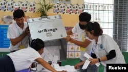 Election officials count ballots at a polling station on the day of Cambodia's general election, in Phnom Penh, Cambodia, July 23, 2023.
