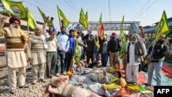 Members of the farm union Bharatiya Kisan Union (Ekta Ugrahan) block railway tracks and shout slogans during a protest to demand minimum crop prices at a railway station in Rajpura on Feb. 15, 2024.