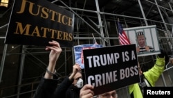Protestors stand outside the Manhattan District Attorney's office as the investigation continues into $130,000 paid before the 2016 presidential election to a porn star who said she had a sexual encounter with former U.S. President Donald Trump in 2006.