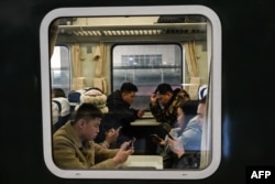 People ride on a train at Shijiazhuang train station on Feb. 6, 2024.