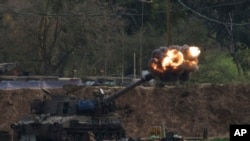 ইসরাইল-গাজা সীমান্তের কাছে এক জায়গায় ইসরাইলের দক্ষিণাঞ্চল থেকে গাজা ভূখণ্ডের দিকে গোলা বর্ষণ করছে ইসরাইলের চলমান এক কামান ইউনিট। ২২ ফেব্রুয়ারি, ২০২৪। 