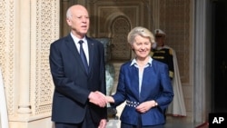 In this photo provided by the Tunisian Presidency, Tunisian President Kais Saied, left, shakes hand with European Commission President Ursula von der Leyen at the presidential palace in Carthage, Tunisia, July 16, 2023.