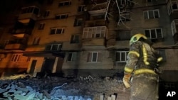 ইউক্রেনের জরুরি পরিষেবা দ্বারা সরবরাহ করা এই ছবিতে একজন দমকলকর্মী ২০২৪ সালের ২৩ ফেব্রুয়ারি ইউক্রেনের ডিনিপ্রোতে রাশিয়ার একটি ড্রোন হামলার পরে একটি অ্যাপার্টমেন্ট ভবনের ক্ষয়ক্ষতি পরীক্ষা করছেন। ২৩ ফেব্রুয়ারি, ২০২৪। 