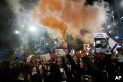 Demonstrators wave signs and shout slogans during a protest calling for the release of hostages held in the Gaza Strip by the Hamas militant group, in Tel Aviv, Israel, Feb. 24, 2024.
