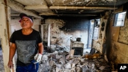 A resident of Vina de Mar, Chile, stands in his home that burned when forest fires that broke out three days earlier reached his neighborhood, Feb. 5, 2024. 