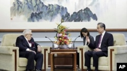 In this photo released by China's Ministry of Foreign Affairs, former Secretary of State Henry Kissinger, left, meets with Chinese State Councilor Wang Yi in Beijing, Wednesday, July 19, 2023. 