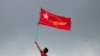 FILE - A supporter of National League for Democracy party holds a flag from a boat in the Yangon river, Myanmar, Oct. 28, 2020. 
