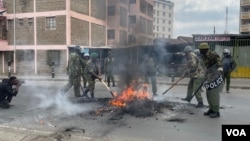 Riot police extinguish burning tires in Nairobi, Kenya, July 19, 2023. (Mariama Diallo/VOA)
