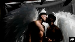 Men wearing angel wings share a kiss in downtown Buenos Aires, Argentina, Nov. 4, 2023, where thousands have gathered to commemorate the 32nd annual Pride Parade. 