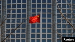 FILE - A Chinese flag flutters outside the Chinese foreign ministry in Beijing, China, Feb. 24, 2022.