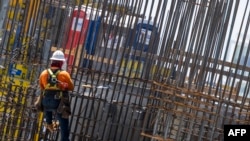FILE - Construction workers help erect a building in Miami, June 14, 2023. Construction workers say they are losing their jobs because employers fear Florida's new immigration law.