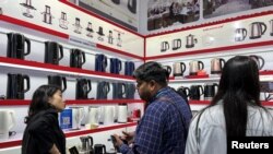 资料照：广州举办的广交会上一个家用小电器生产商举办人员与参观者交谈。（2023年4月16日）