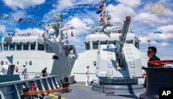 In this photo released by the official Facebook page of the Ream Naval Base, Cambodian navy crew stand on a patrol boat at the Ream Naval Base in Sihanoukville, southwest of Phnom Penh, Dec. 3, 2023.