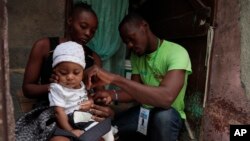 A local health worker measures the arm circumference of a 6-month-old girl who is suffering from malnutrition in Port-au-Prince, Haiti, July 13, 2023.