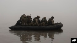 FILE - Ukrainian marines sail along the Dnipro river at the front line near Kherson, Ukraine, Oct. 14, 2023. 