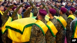 Hezbollah fighters surround the coffin of Abbas Raad, son of the head of Hezbollah's parliamentary bloc, Mohammed Raad, who was killed by an Israeli strike, during his funeral procession in Jbaa, Lebanon, Nov. 23, 2023.