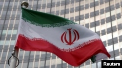 FILE — The Iranian flag flutters in front of the International Atomic Energy Agency organization's headquarters in Vienna, Austria, June 5, 2023.