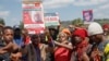 Family, friends and fellow protesters carry a photo of Rex Masai, who was shot by the police during Kenya's anti-finance bill protest, as they chant slogans to show their respects during his burial in Machakos County, Kenya, on July 5, 2024. 