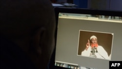 ফাইল- কেনিয়ার নাইরোবিতে এক ব্যক্তি কম্পিউটার স্ক্রিনে সোমালি বংশোদ্ভূত ধর্মীয় নেতা এবং ইসলামিক স্টেট-সোমালিয়ার নেতা আবদুল কাদির মুমিনের ছবি প্রদর্শন করছে। ১ সেপ্টেম্বর, ২০১৬। 