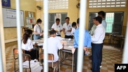 Election officials count ballots at a polling station in Phnom Penh on July 23, 2023 during the general elections. (Photo by TANG CHHIN SOTHY / AFP)