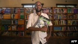 This handout picture taken on Nov. 8, 2023, shows Abdullahi Mire, winner of the U.N. refugee agency's prestigious Nansen Award, posing for a picture in one of the libraries he established in Kenya's Dadaab refugee camp. (AFP Photo/UNHCR)