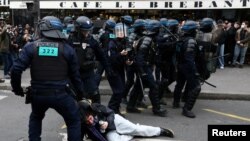 French riot police apprehend a protester amid clashes during a demonstration as part of nationwide strikes and protests against French government's pension reform, in Paris, March 23, 2023.