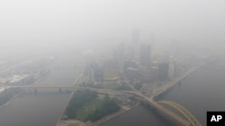 FILE - Haze from Canadian wildfires blankets the downtown Pittsburgh skyline as seen from Elliott, Pa., June 28, 2023.