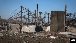 A local resident walks through the ruins of a farm after a recent Russian rocket attack in the village of Kiseliovka close to Kherson, Ukraine, Nov. 10, 2023.
