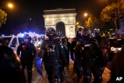 Police officers patrol in front of the Arc de Triomphe on the Champs Elysees in Paris, July 1, 2023.