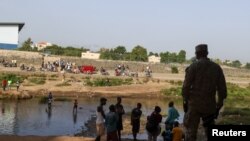 Un miembro del Ejército Nacional observa a los haitianos mientras custodia el puente entre República Dominicana y Haití, tras un cierre de la frontera compartida en Dajabón. República Dominicana, el 8 de julio de 2021.