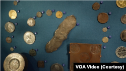 Українська срібна гривня (в центрі) посеред колекції російських грошей