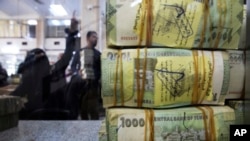 FILE - A stack of Yemeni riyals rests on the counter at the Central Bank of Yemen's internationally recognized government, in Aden, Yemen, Dec. 13, 2018.