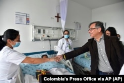 In this handout photo released by the Colombian Presidential Press Office, President Gustavo Petro greets a nurse tending to one of the four Indigenous children at a military hospital in Bogota, June 10, 2023.