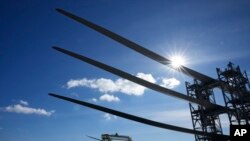 A generator and its blades, bottom, are tugged at sea leaving State Pier in New London, Conn., Dec. 4, 2023, heading to South Fork Wind farm.